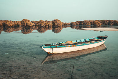 Boat moored in sea against sky