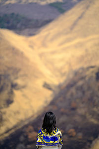 Rear view of woman standing in front of a  mountain