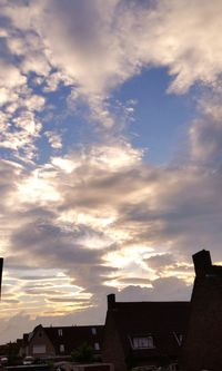 Low angle view of houses against cloudy sky