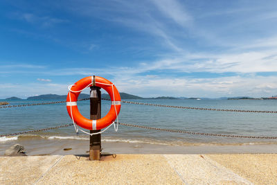 Lifeguard hut on wooden post at beach against sky