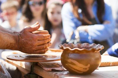 Midsection of potter making bowl in market