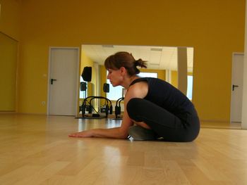 Young woman sitting on hardwood floor