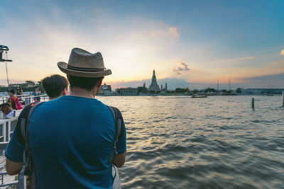 Rear view of man looking at sea against sky