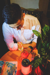 High angle view of young man holding apple