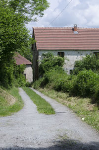 Road amidst buildings against sky