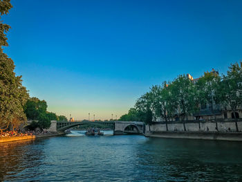 Bridge over river against clear blue sky