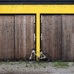 Bicycle parked against yellow wall in old building