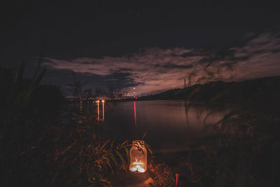 Illuminated scenic view of lake against sky at night