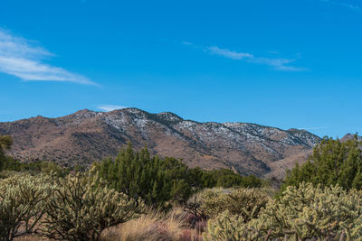 Scenic view of mountains against blue sky