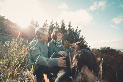 Couple with dog sitting in field