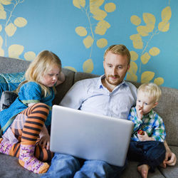 Father with daughter and son using laptop