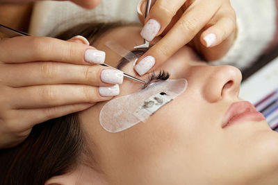 Cropped image of woman applying nail polish