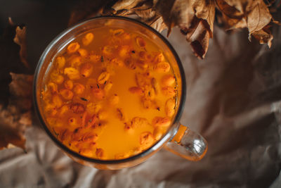 Close up llarge mug of hot orange sea buckthorn tea in a cozy home autumn evening still life