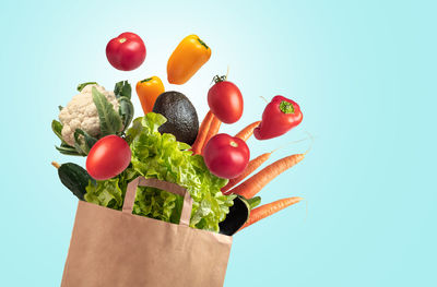 Recyclable bag of fresh vegetables on blue summer sky background