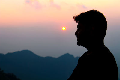 Side view of silhouette man against sky during sunset