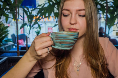 Close-up portrait of young woman drinking food