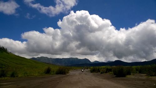 Country road against cloudy sky