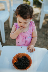 Baby girl eating blackberry