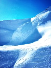 Snow covered mountain against blue sky