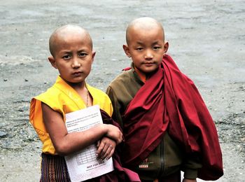 Portrait of monk boys standing outdoors