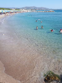 People on beach against blue sky