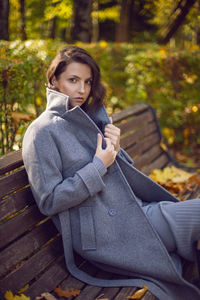 Young woman using mobile phone while sitting on bench