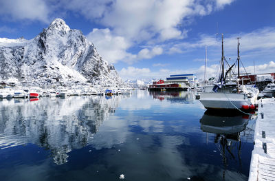 Sailboats moored on sea against sky