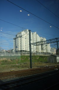 Railroad tracks by buildings against sky