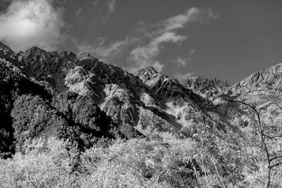 Low angle view of snowcapped mountains against sky