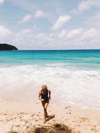 Woman at beach against sky