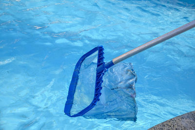 Cleaning pool from garbage with special net. clear water with blue tint. 