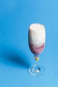 Close-up of wineglass against blue background