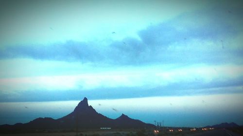 Scenic view of mountains against cloudy sky