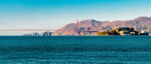 Scenic view of bay against clear blue sky