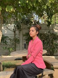 Portrait of young woman sitting outdoors