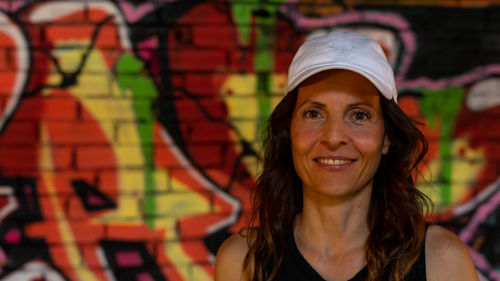 Woman with visor in front of graffiti