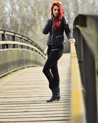 Portrait of beautiful redhead woman standing on footbridge