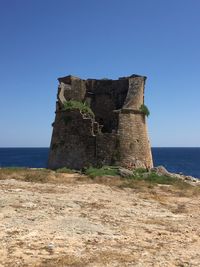 Built structure on beach against clear blue sky