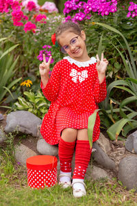 A funny little girl in a red dress with polka