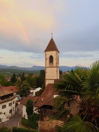 A small village in italy with a rainbow next to the church