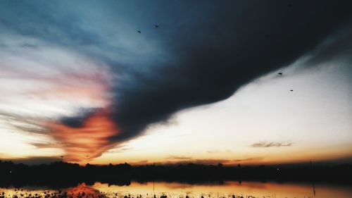 Scenic view of dramatic sky over silhouette landscape