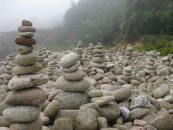 Stack of pebbles on landscape against sky