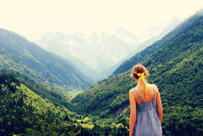 Rear view of woman standing in front of mountains