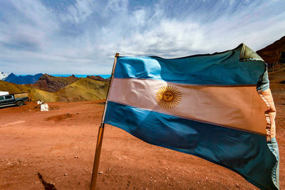 Scenic view of flag on mountain against blue sky