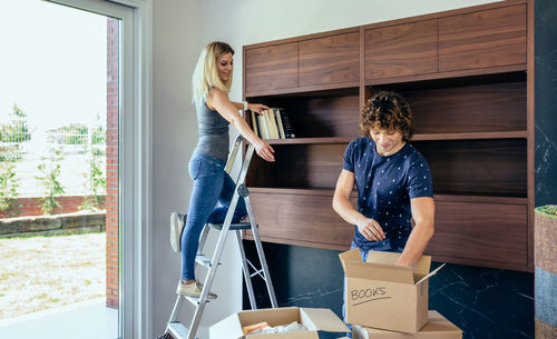 Couple adjusting books at new home