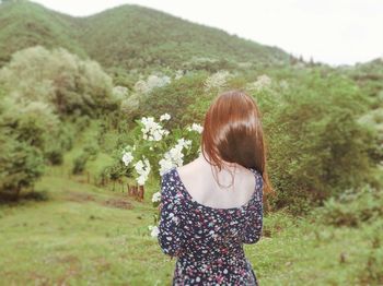 Rear view of woman standing on field