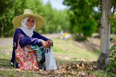 Woman wearing hat against trees