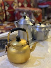 Close-up of golden kettle on table