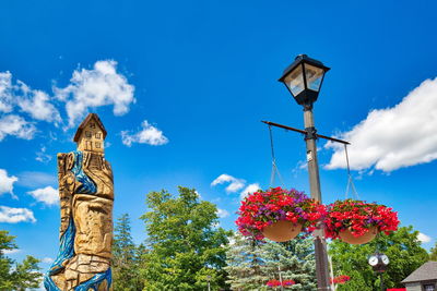 Low angle view of street light by building against sky