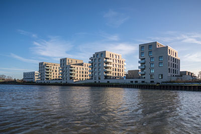 River by buildings against sky in city